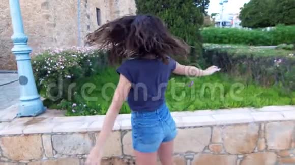 快乐的女孩挥舞着双手跳着快乐的游客在街上散步视频的预览图