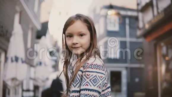 小欧洲女孩57岁的肖像对着镜头微笑惊人的长发旧房子的背景4K视频的预览图