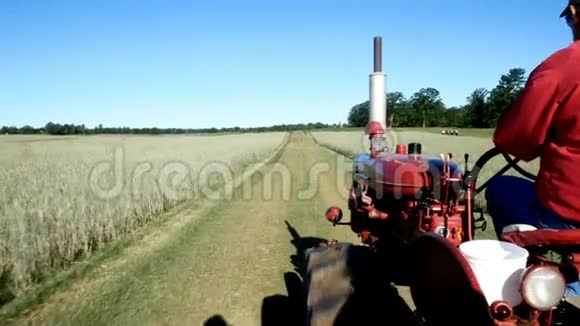 旧的红色拖拉机在农场上移动现代农业运输机器驾驶4个夹子视频的预览图