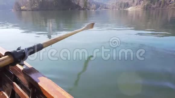 4K视频阳光明媚的一天水中划桨划船船上的岛屿湖在倒影中流血湖在流血视频的预览图
