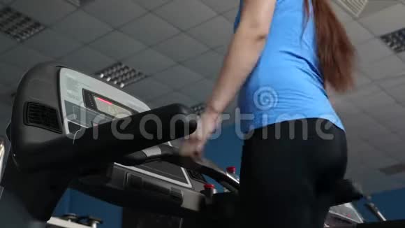 健身俱乐部性感女孩从事散步跑步机上的女孩有氧运动负荷加强心脏和腿部肌肉视频的预览图