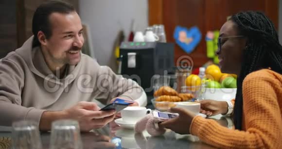 新婚夫妇在家中酒吧喝咖啡在网上购物视频的预览图