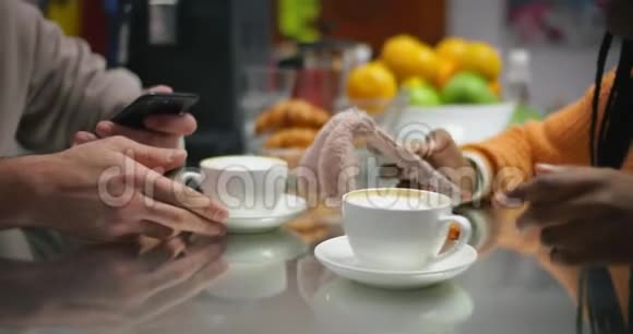 背景上有手机的男人和女孩的手两杯咖啡视频的预览图