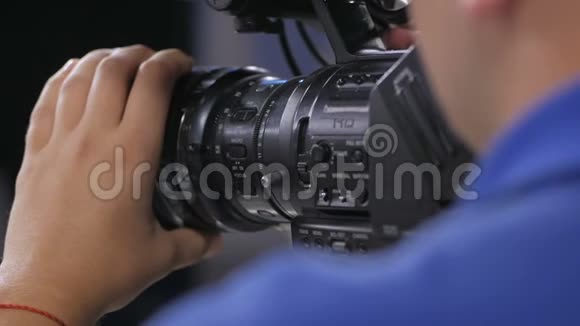 摄像机操作员与电影院广播电视摄像机一起工作背面视频的预览图