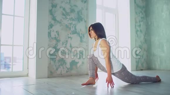 年轻女子在健身房做伸展运动年轻漂亮的女人练习瑜伽健康观念冷静和冷静视频的预览图