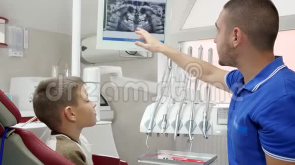 专业医生为牙科扶手椅中的病人提供特殊设备背景和牙科屏幕方面的建议视频的预览图