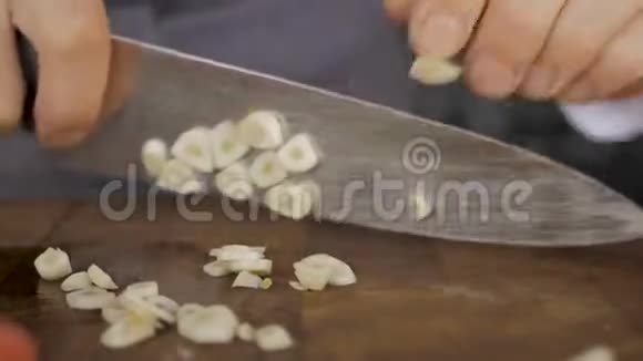厨师用刀切割切割板上的大蒜视频的预览图