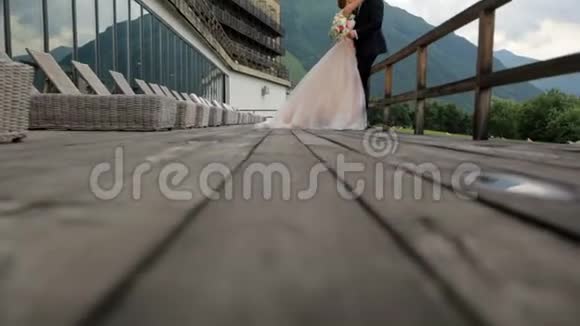 结婚美丽的新娘和新郎在他们的婚礼上在酒店和雄伟的山脉的背景下视频的预览图
