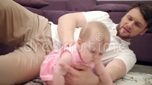 可爱的宝贝和爸爸玩婴儿爬向妈妈幼儿女孩爬行视频的预览图