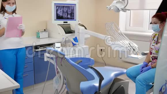 小女孩带着现代化的设备来到牙科办公室由女口腔医生治疗牙齿视频的预览图