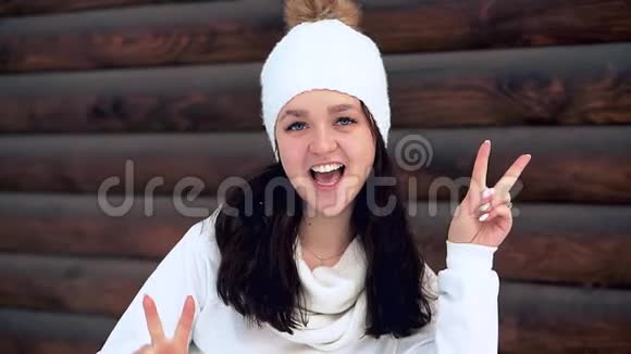 和平的人一个穿着白色衬衫和白色帽子的快乐迷人女孩的肖像视频的预览图