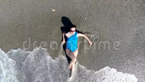 一个女孩在度假时躺在沙滩上视频的预览图