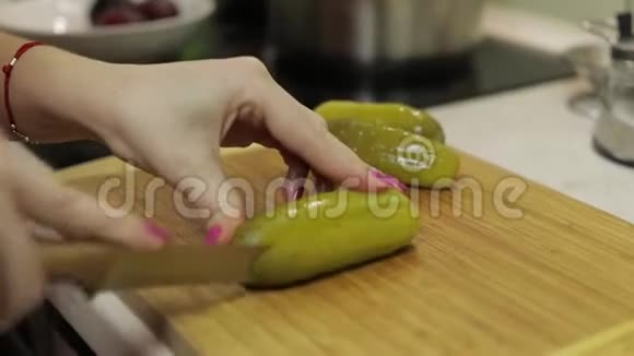 女家庭主妇在厨房里用手把腌制好的黄瓜切成碎片视频的预览图