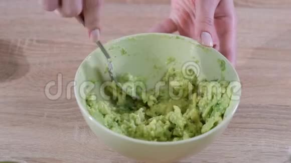 女人手的特写用叉子在碗里打鳄梨视频的预览图