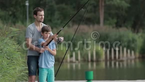 十几岁的男孩在父亲的帮助学会钓鱼视频的预览图