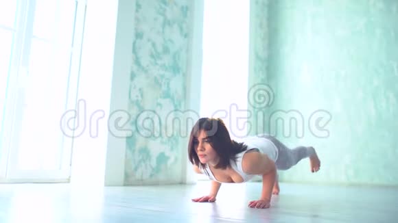 一位穿着运动服的年轻女士在垫子上做瑜伽运动灵活的女孩视频的预览图