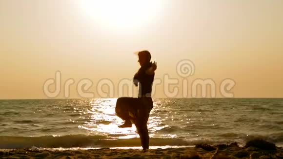 在海滩上做瑜伽练习的女孩视频的预览图