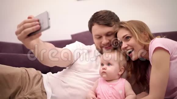 父母亲吻宝宝幸福的家庭在家自拍视频的预览图