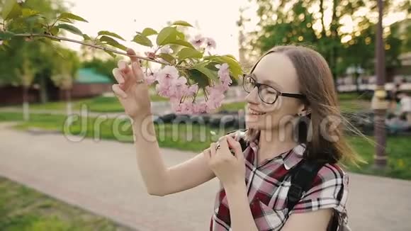 穿着随意的女孩有樱花树花专心面对春天的概念慢动作视频的预览图