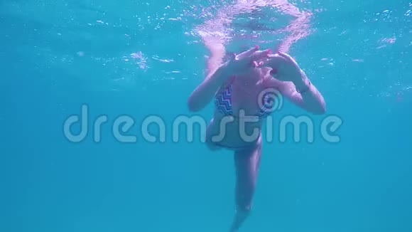 蓝色海洋中游泳的年轻女子的水下景观视频的预览图