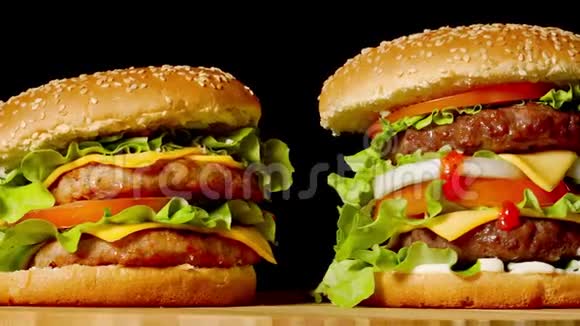 美国快餐的概念带有两个牛肉片的美国辣汉堡加酱和黑肉视频的预览图