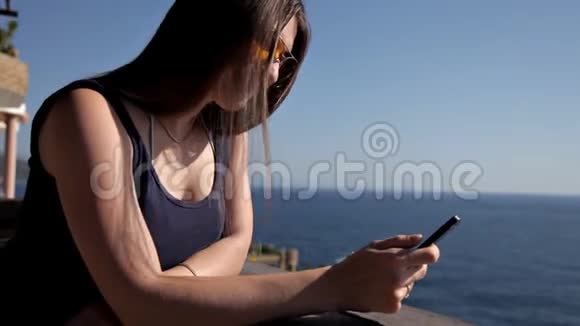 一个年轻的女孩从豪华的露台上眺望大海在阳台上享受蓝天的女人视频的预览图