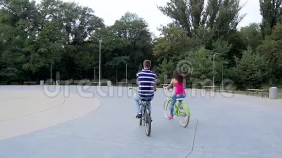一对夫妇骑着自行车在公园里从后面看石头视频的预览图