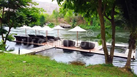泰国葵坎查纳布里河附近度假胜地的海滨木筏上的躺椅或日光浴床和雨伞旅游和度假视频的预览图