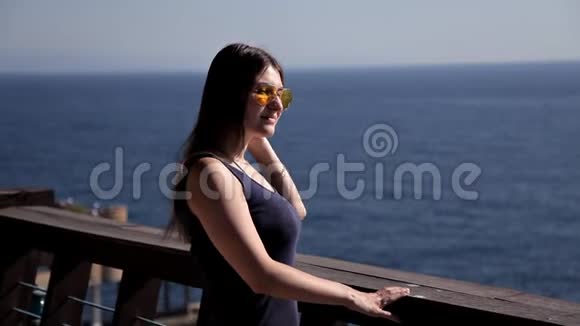一个年轻的女孩从豪华的露台上眺望大海在阳台上享受蓝天的女人视频的预览图