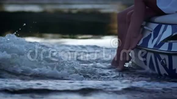 人腿在发泡水流中喜欢情侣晚上在河上划船视频的预览图