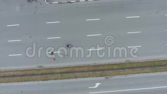 在城市道路马拉松比赛中一组运动员和自行车手的高空向下投篮视频的预览图