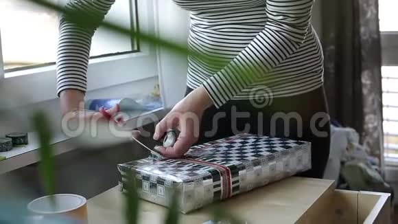 带着透明胶带的女性手在包装礼物视频的预览图