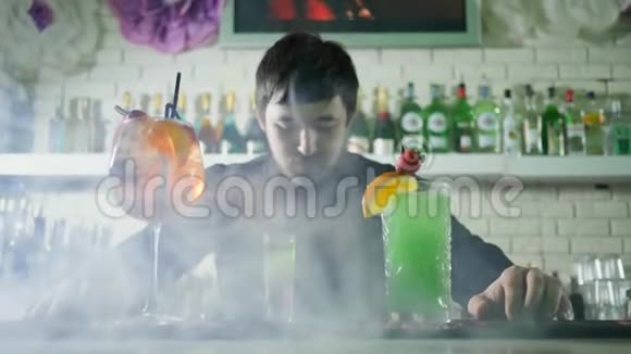 酒吧内部薄雾中带水果的彩色酒精饮料柜台青年男子画像视频的预览图