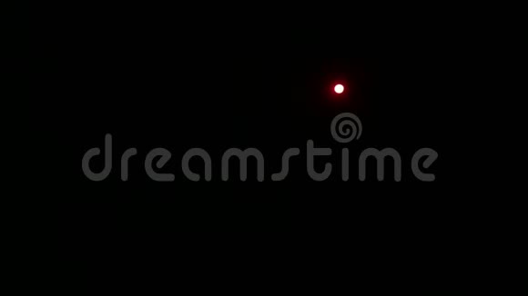 一束红光从聚光灯射向舞台在完全黑暗中视频的预览图