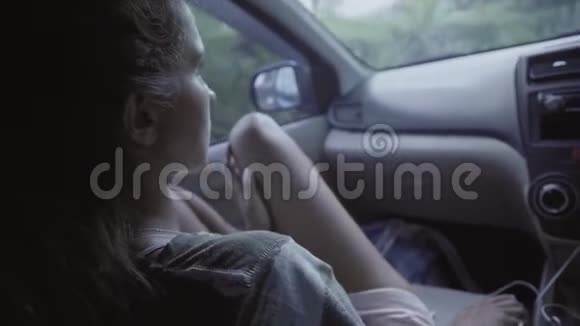年轻的棕色眼睛的女人赤着膝盖坐在移动的汽车视频的预览图
