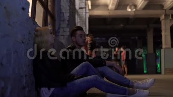 金发女人和男人坐在墙边聊天派对后夜生活视频的预览图