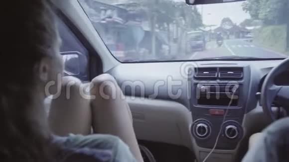 年轻的白种人男女坐在车里在亚洲热带农村地区开车视频的预览图