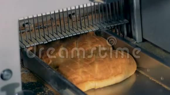 面包切片特写机械切割机在一家面包厂工作视频的预览图