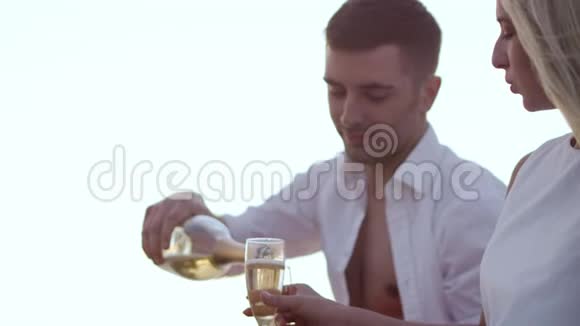 可爱的年轻夫妇在日落时喝酒恋爱中的男朋友和女朋友视频的预览图