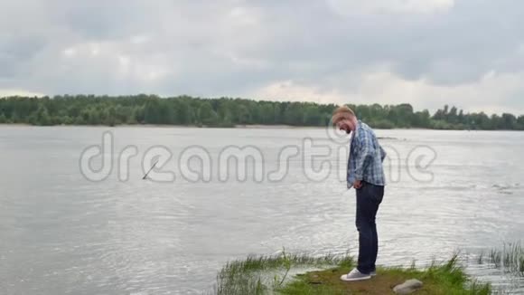 年轻人走在河边男人看着河游客在湖边散步视频的预览图