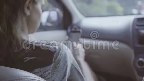 镜头显示年轻女子带着智能手机在车里然后可爱的长发男视频的预览图