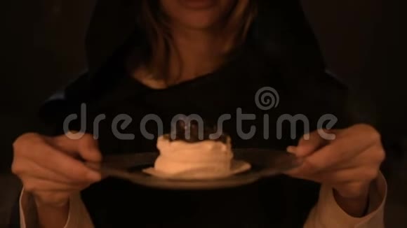 烛光下一个心满意足的女魔术师在黑暗的房间里做了一个蛋糕把一盘蛋糕放低视频的预览图