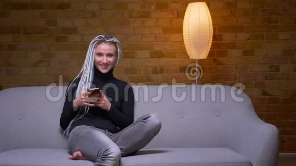 一位年轻迷人的白种人时髦女性的特写镜头她的金发美女在电话里发短信视频的预览图