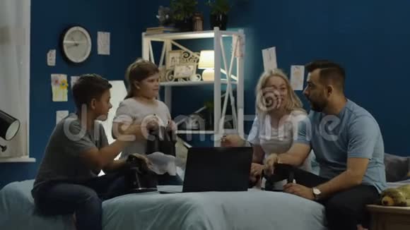 一家人戴着VR眼镜坐在床上视频的预览图