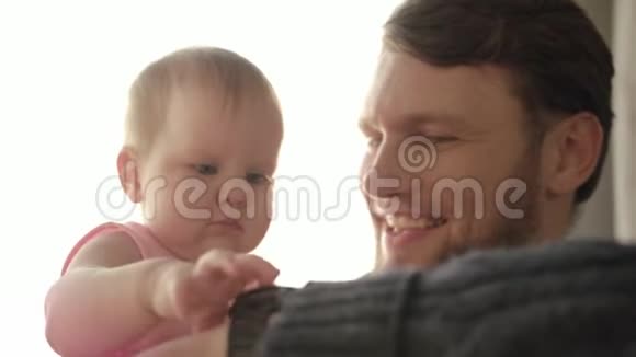 大胡子爸爸亲宝宝父亲的时间观念婴儿触摸手表视频的预览图