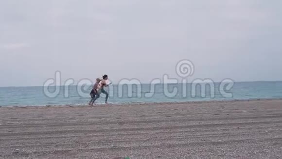 年轻夫妇在海滩上跑步视频的预览图
