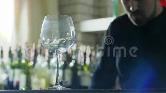 手里拿着勺子的家伙慢慢地把冰块加入到酒吧特写的透明酒杯里视频的预览图