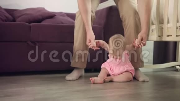 人生的第一步美丽的女婴站在父亲的支持下视频的预览图