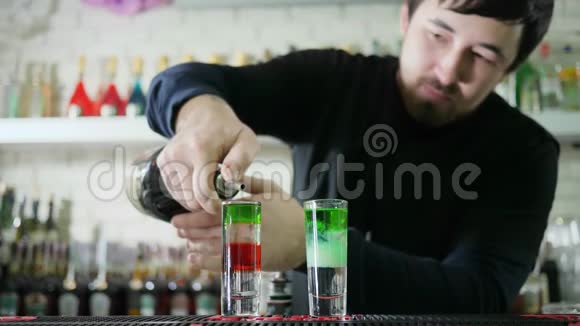 专业的酒吧老板在酒吧里用酒精把明亮的饮料慢慢地从瓶子里倒入玻璃里视频的预览图