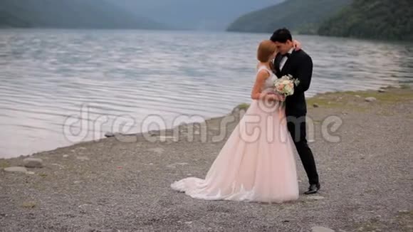 在河和山的背景下相爱的一对幸福婚姻生活的概念视频的预览图
